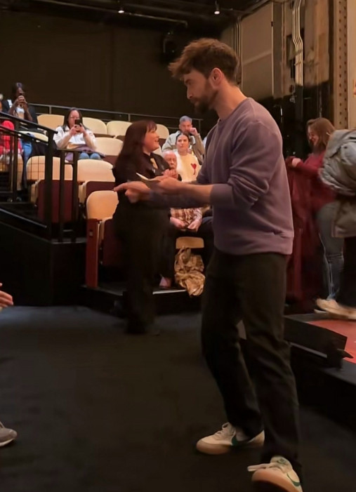 Дэниел Рэдклифф раздает карточки зрителям